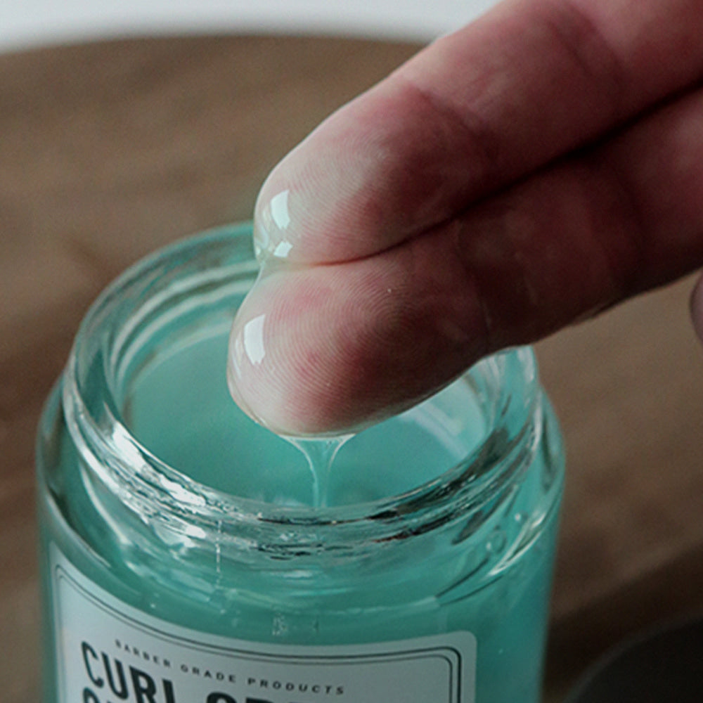 GRAFEN  Curl Cream Sea Water 100g : crème boucles GRAFEN en gros plan, main ouvrant le pot sur fond clair