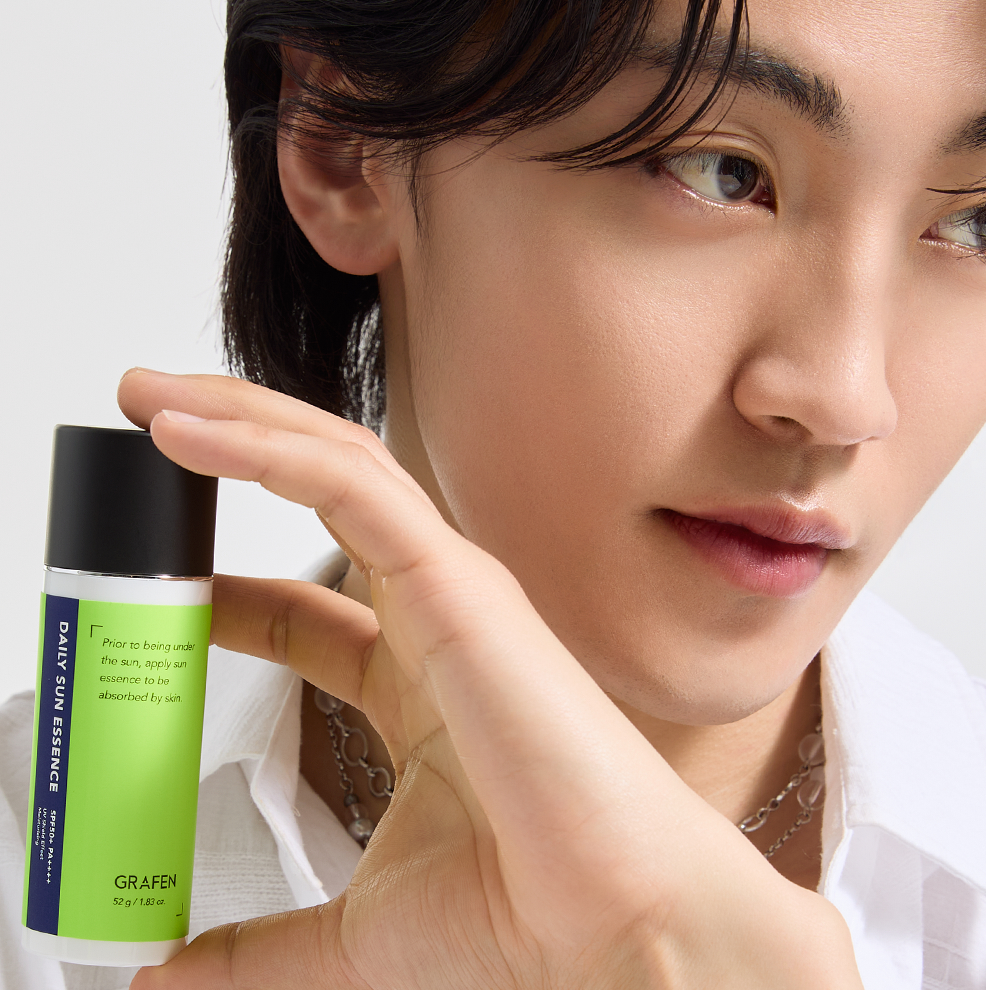 GRAFEN  Daily Sun Essence 52g : sérum visage vert, jeune femme l’applique en studio sur fond clair (marque GRAFEN).