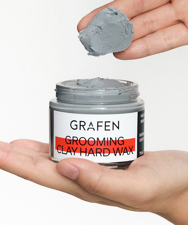 GRAFEN  Grooming Clay Hard Wax 75ml : pot de cire coiffante dans la main, texture argile grise, fond clair.