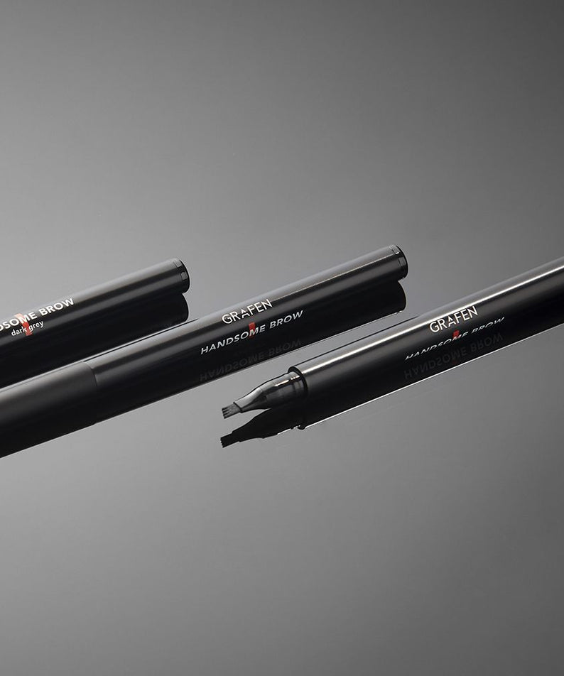 GRAFEN  Handsome Tattoo Brow 0.8g, stylos à sourcils tatouage, pack noir sur fond gris, main ouverte, vue produit