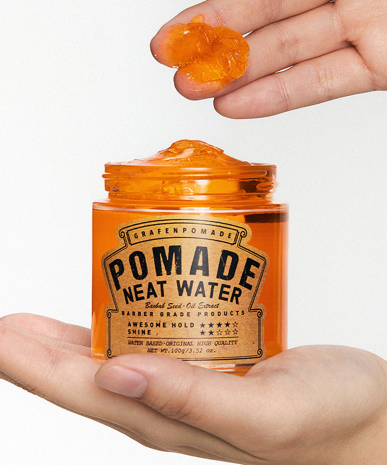 GRAFEN  Pomande Neat Water 100g : pot cosmétique orange tenu en main, avec une pommade brillante sur les doigts, fond clair.