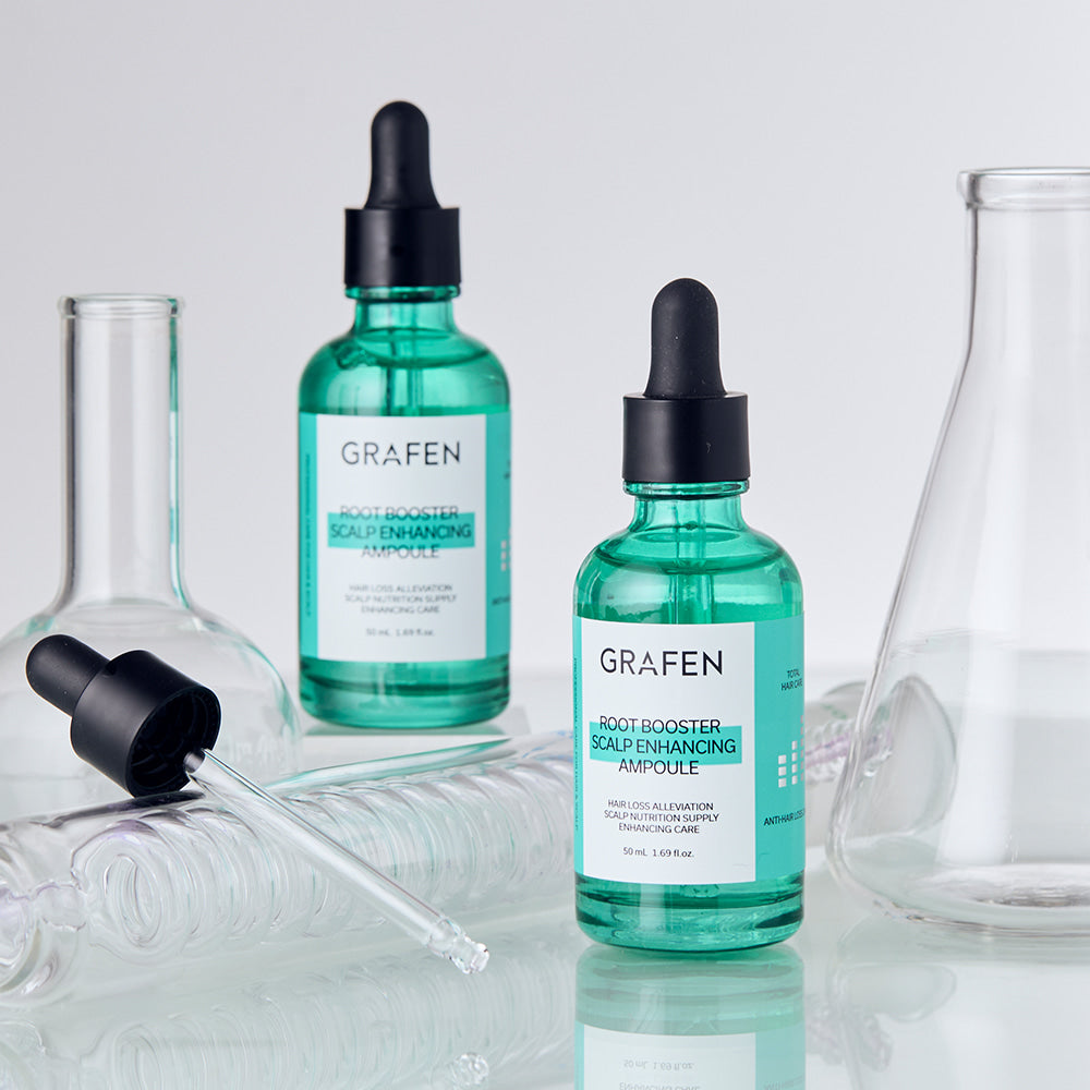 Décris l'image en français : flacons GRAFEN Root Booster Ampoule 50ml, ambiance salle de bain sur fond clair.