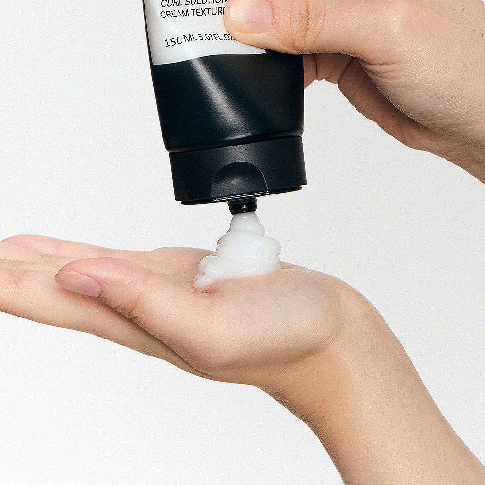 GRAFEN  Volume Up Curl Cream 150ml, tube appliqué sur les mains, crème texturisante pour boucles sur fond clair.
