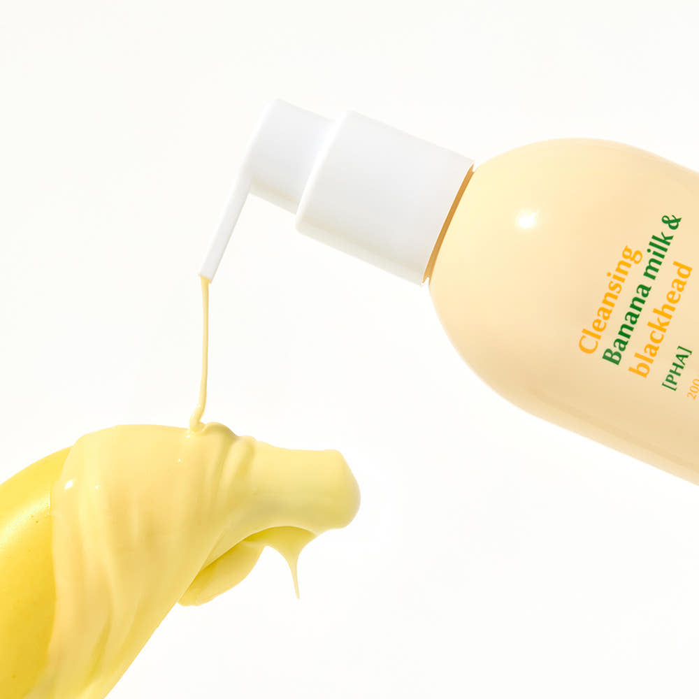 Main tenant HANSKIN Cleansing Banana Milk & Blackhead PHA 200ml, flacon de marque sur fond clair, texture crème