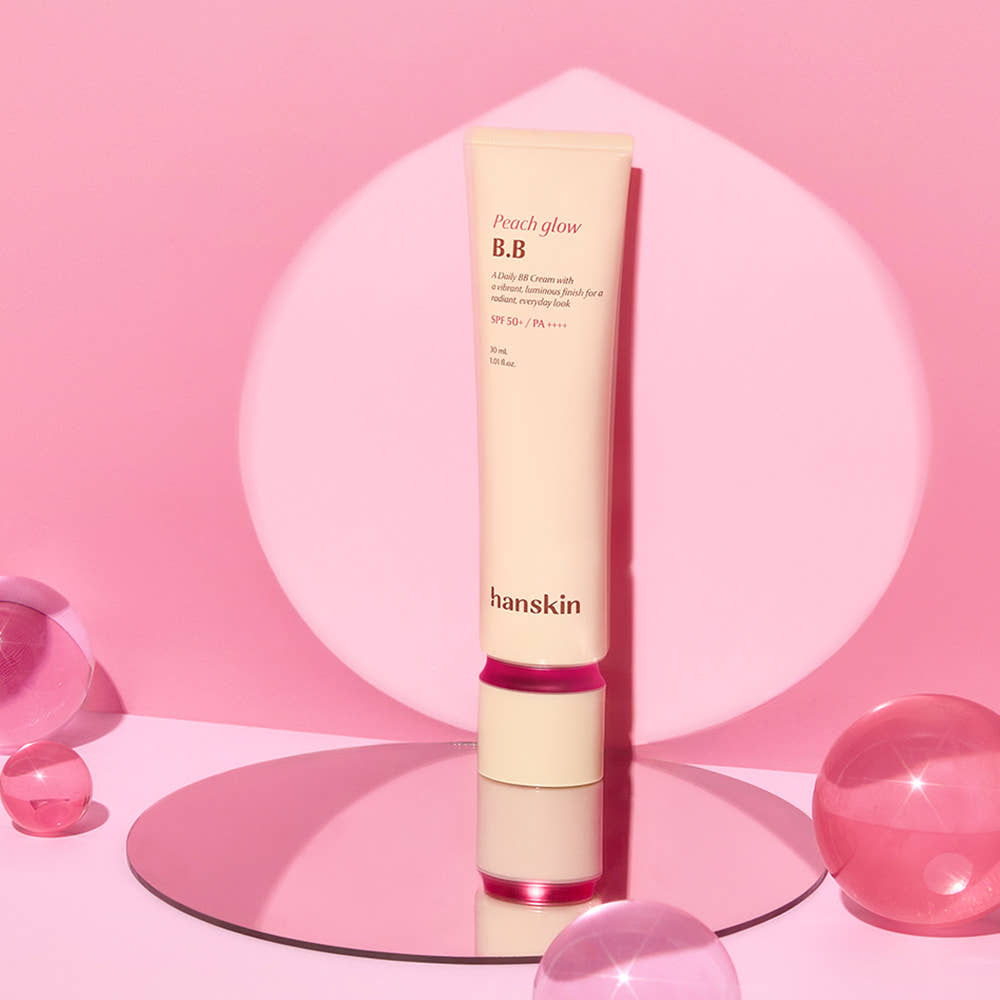 HANSKIN Peach Glow BB Cream 30ml, tube sur fond rose, ambiance maquillage, marque HANSKIN en contexte visuel beauté.