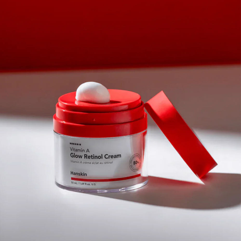 HANSKIN Vitamin A Glow Retinol Cream 50ml, pot rouge et blanc sur fond minimal rouge, goutte de crème visible