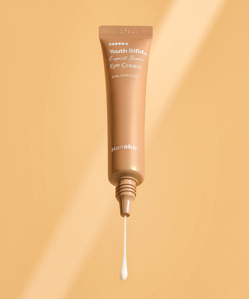 Décris l'image en français en mentionnant le produit, la marque et le contexte visuel : HANSKIN Youth Bifida Expert Biome Eye Cream 15ml sur fond beige.