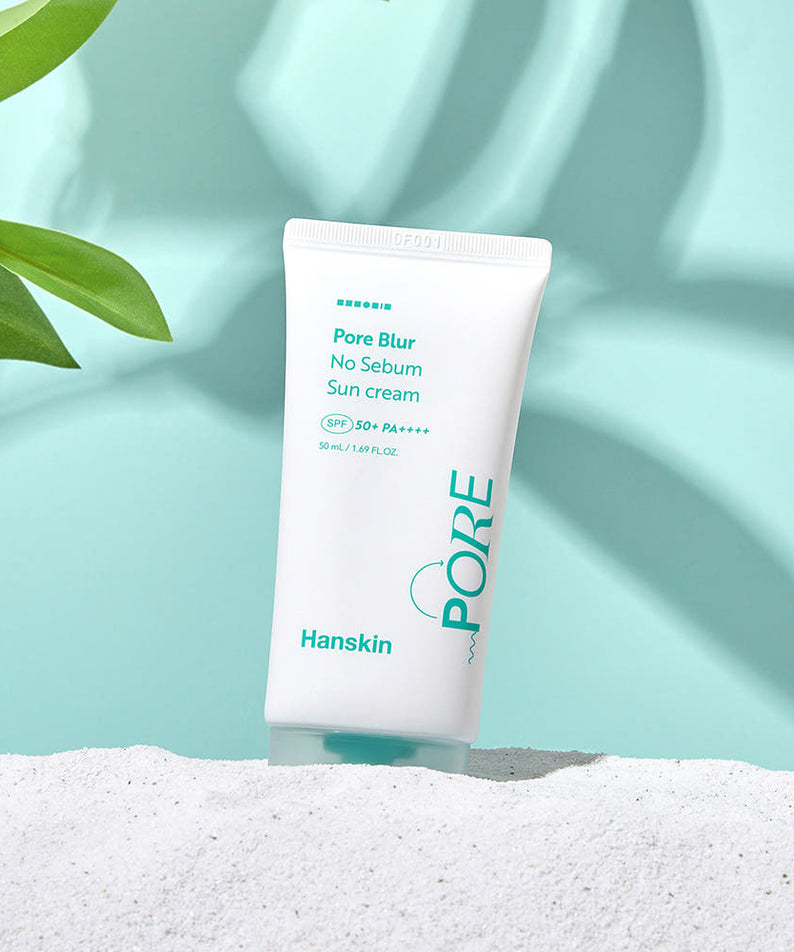 HANSKIN Pore Blur No-Sebum Sunscreen SPF50+ PA++++ 50ml sur fond turquoise, beauté sans sébum, tube de crème solaire posé sur le sable.