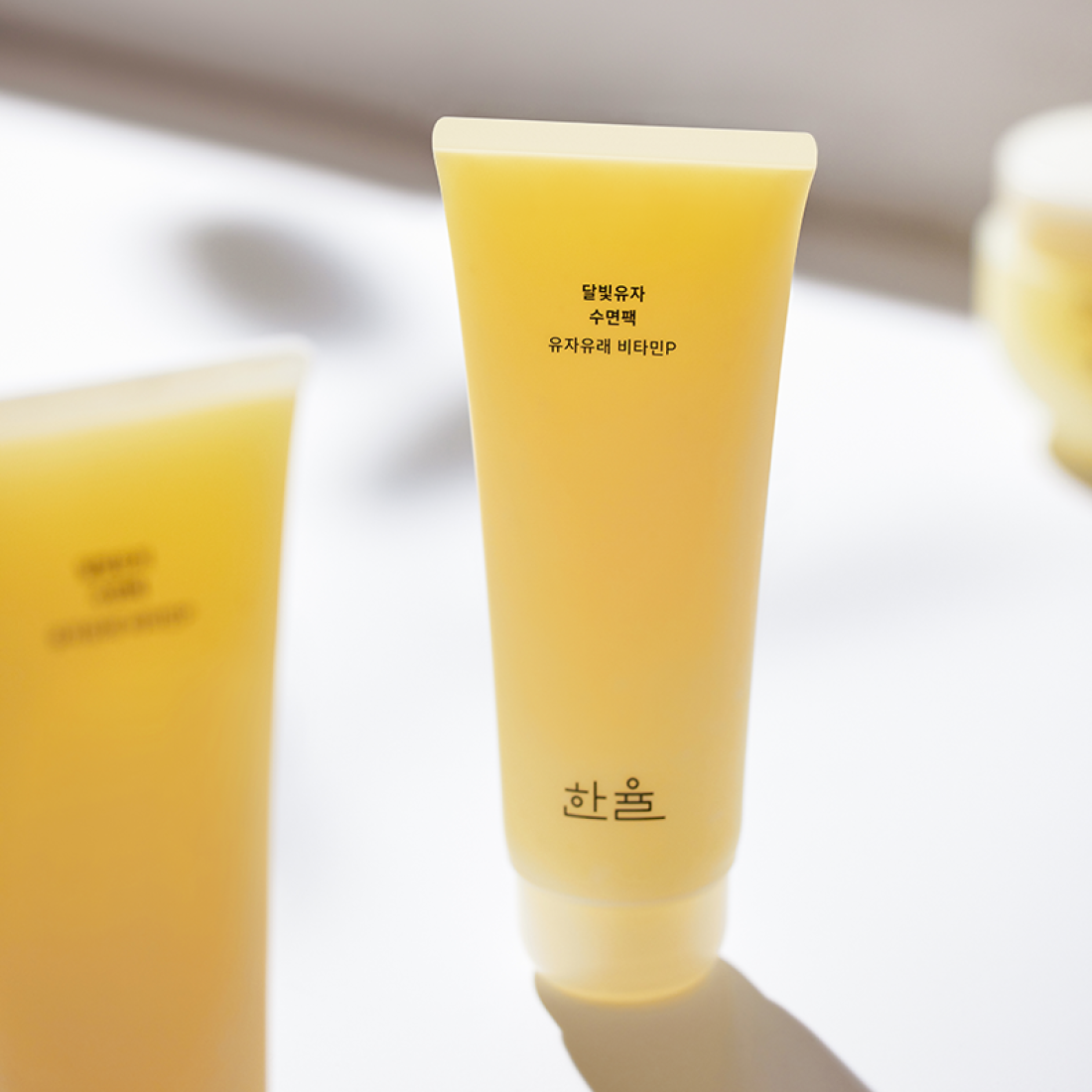 HANYUL Moonlight Yuja Sleeping Pack 100ml, tube de crème jaune sur fond clair, packshot produit beauté Hanyul.