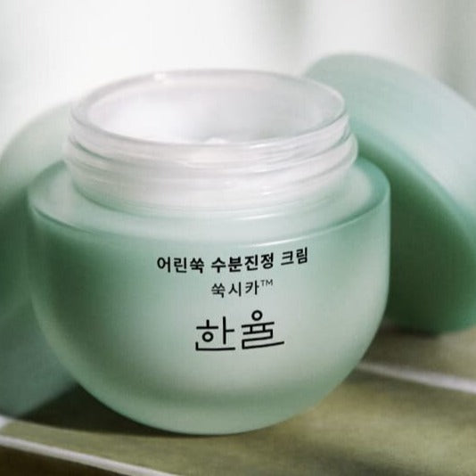 HANYUL Pure Artemisia Calming Water Cream 55ml, pot crème apaisante en vert sur table, marque HANYUL en gros plan.
