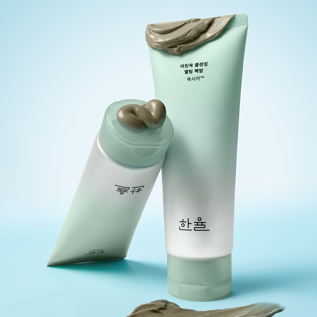 HANYUL Young Artemisia Cleansing Pack Balm 100g de la marque HANYUL, tube vert et texture argileuse sur fond bleu clair