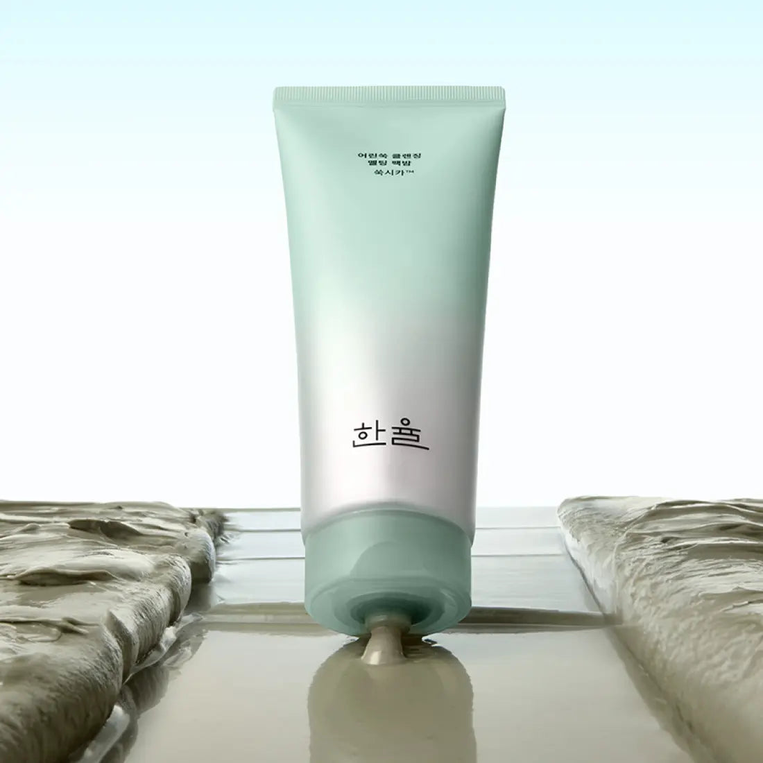 HANYUL Young Artemisia Cleansing Pack Balm 100g, tube vert sur serviettes, ambiance spa, marque HANYUL