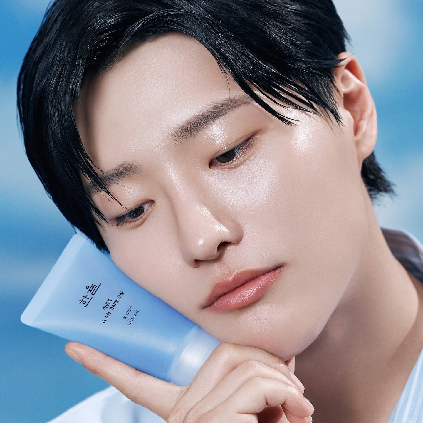 HANYUL Young Artemisia Extract Moisturizing Cream 60ml : crème hydratante HANYUL, modèle visage avec tube bleu sur fond ciel