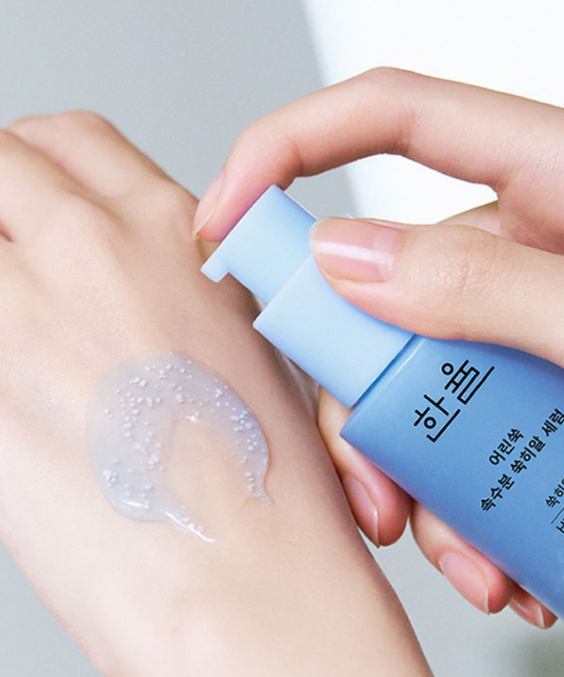 HANYUL Young Artemisia Extract Moisturizing Serum 40ml, application sur peau avec tube bleu, mains et texture crème, fond clair.