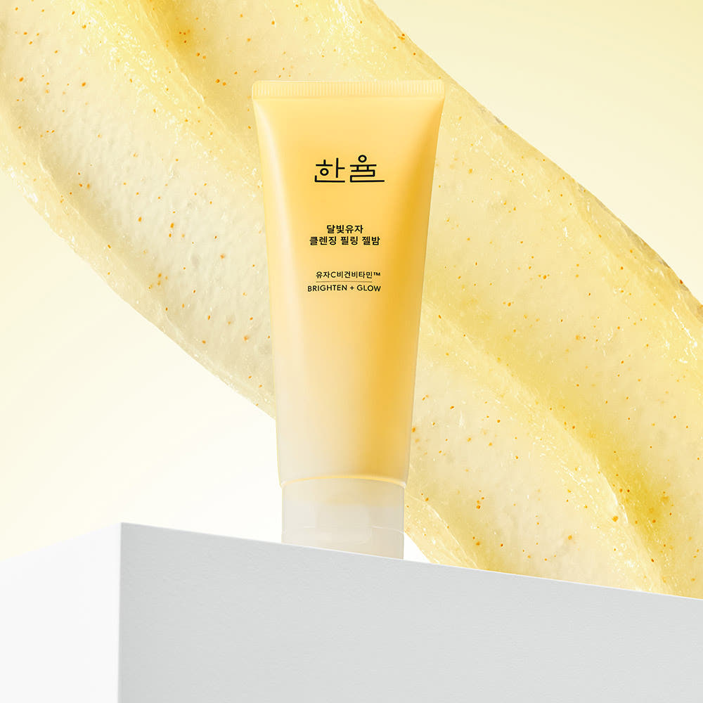 HANYUL Yuja Brightening Peeling Gel Balm Cleanser 100g, tube jaune sur fond blanc, style cosmétique, éclats d’agrumes.