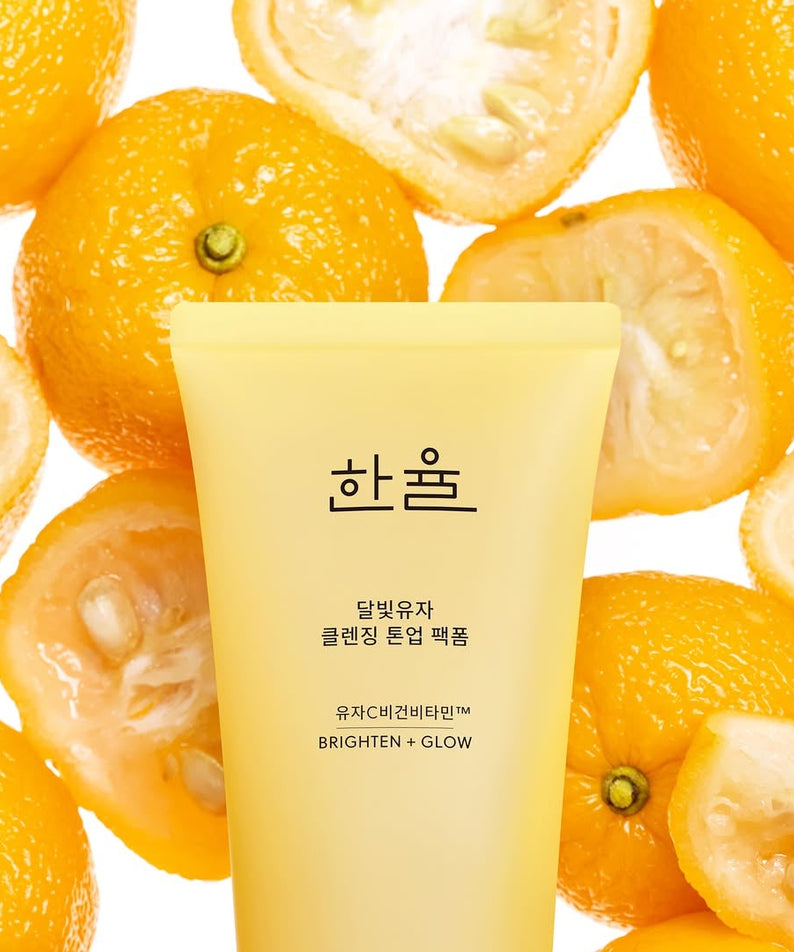 Crème HANYUL Moonlight Yuja Vitamin Tone-Up Pack Foam 120ml devant des yuzus coupés.