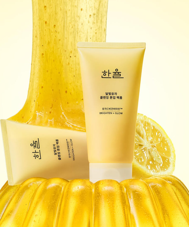 Le produit HANYUL Moonlight Yuja Vitamin Tone-Up Pack Foam 120ml sur fond lumineux, entouré de yuja et texture vibrante.