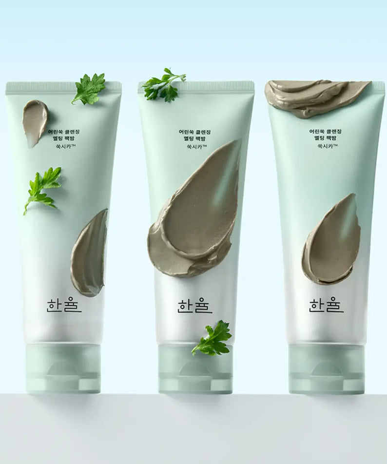 HANYUL Young Artemisia Cleansing Pack Balm 100g, tubes de produit de soin nettoyant à base de plantes avec armoise en arrière-plan.