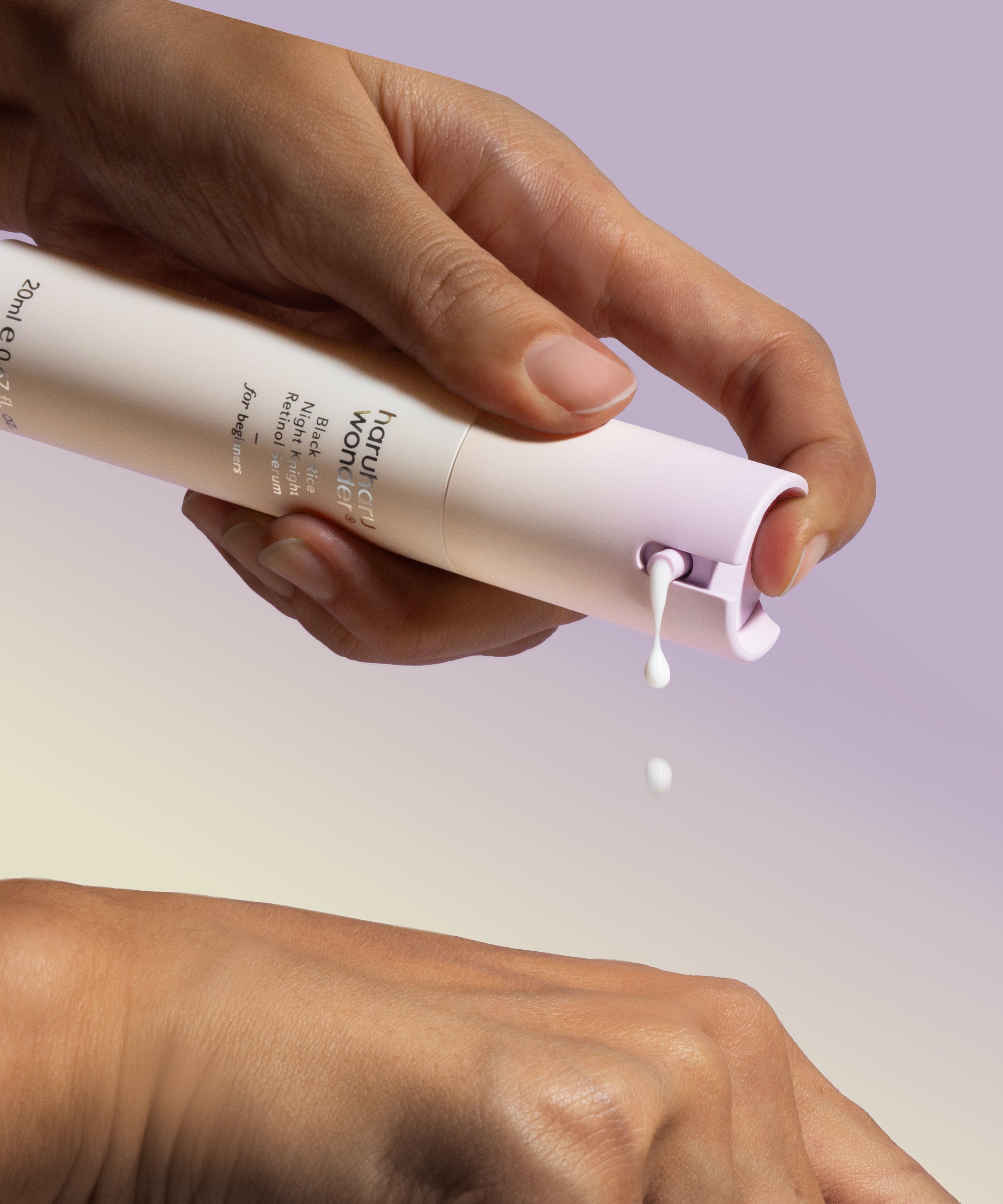 Décris l'image en français : HARUHARU Black Rice Night Night Retinol Serum 20ml de la marque HARUHARU, main appliquant le sérum sur la peau.