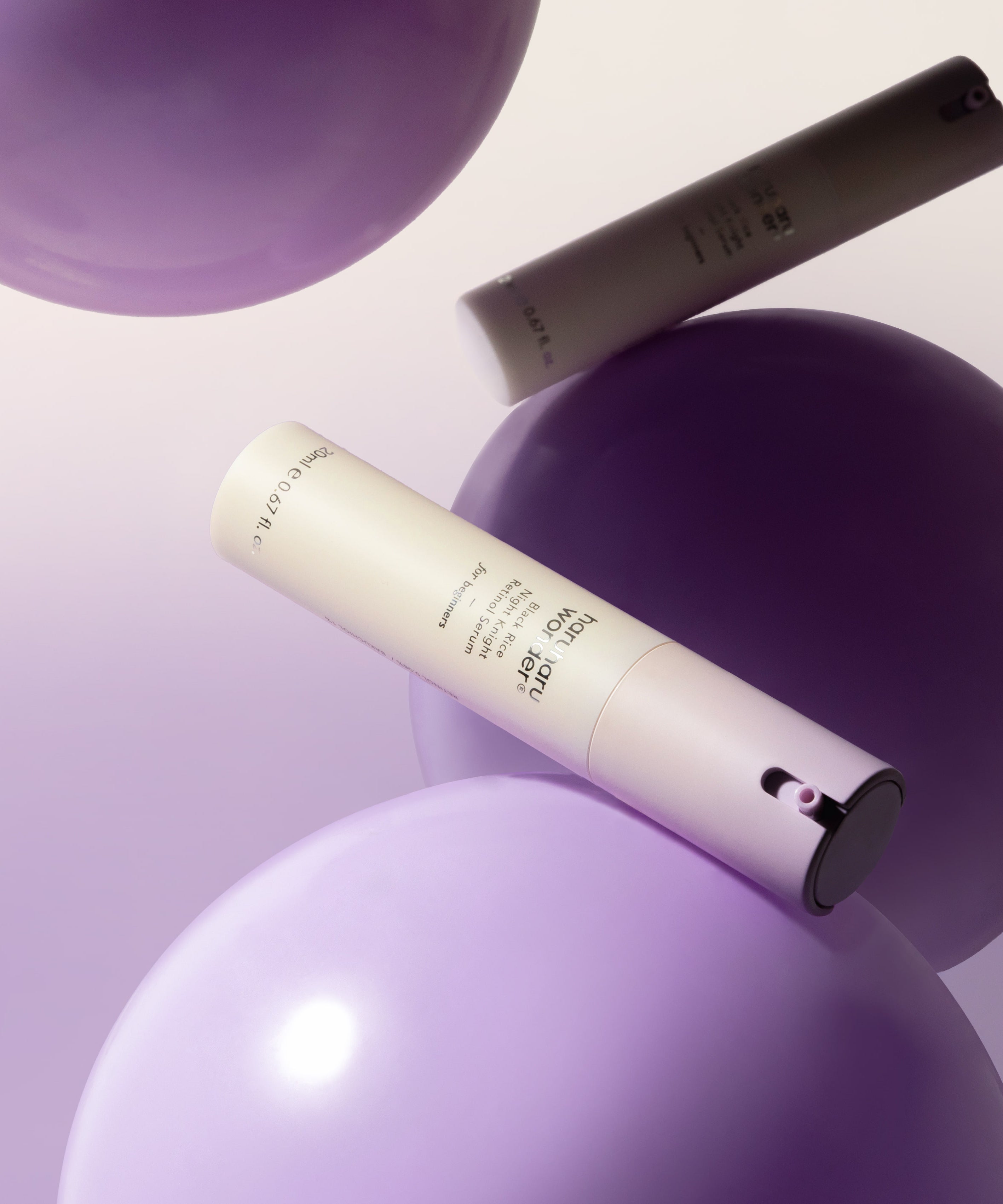 Flacon de HARUHARU Black Rice Night Night Retinol Serum 20ml flottant avec des sphères violettes en arrière-plan.