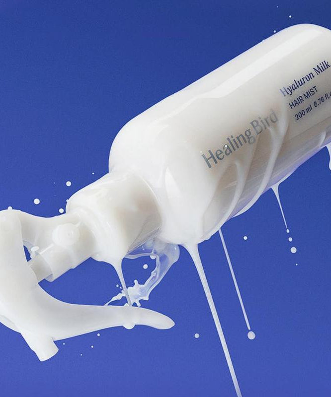 HEALING BIRD Hyalutonic Milk Hair Mist 200ml sur fond bleu, flacon en pulvérisation avec lait coulant, hydratation des cheveux.