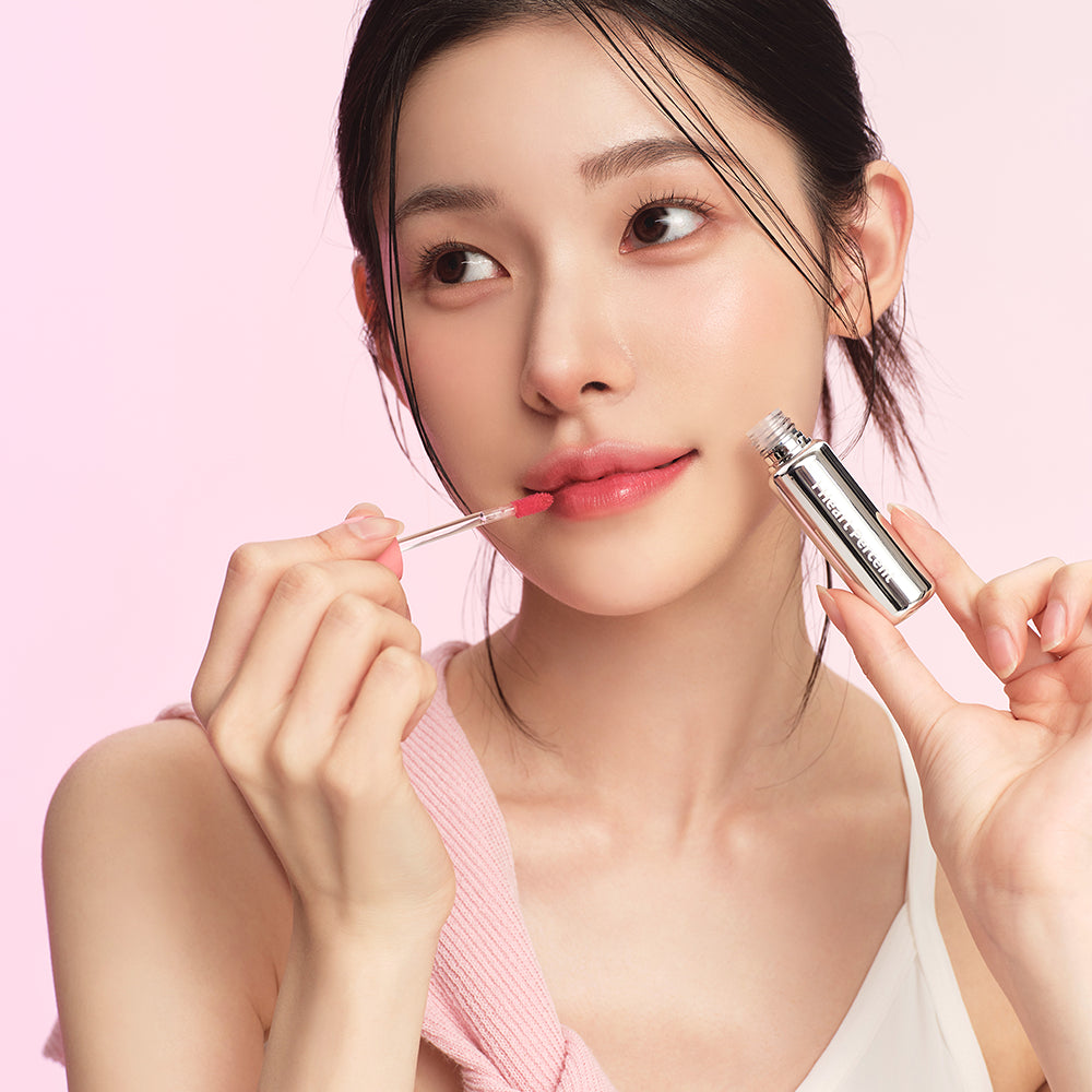 HEART PERCENT Dot On Mood First Tint 3.4g, maquillage sur une femme, tube rose, flacon et application, fond rose.