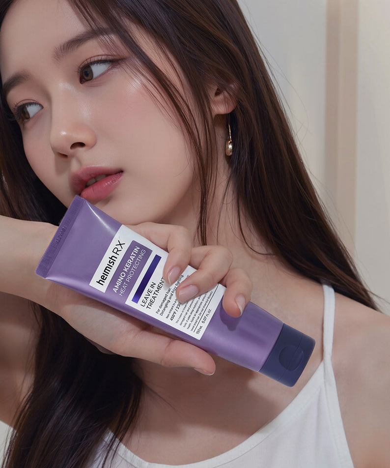 Femme tenant le HEIMISH RX Amino Keratin Heat Protecting Leave-in Treatment 150ml, soin des cheveux pour une protection thermique optimale.