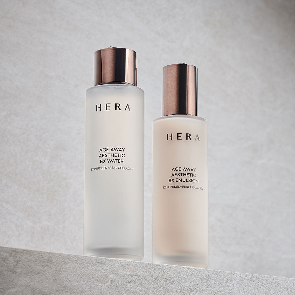 Décris l'image en français : HERA  Age Away Aesthetic BX Water 150ml, deux flacons HERA sur fond clair élégant, contexte studio.