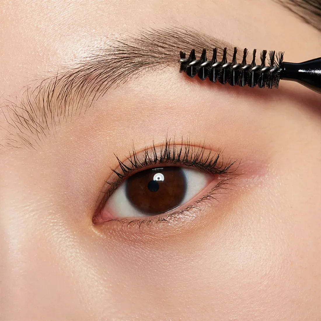 HERA Brow Desighner Auto Pencil de HERA, gros plan sur sourcil avec brosse et application, visage maquillé