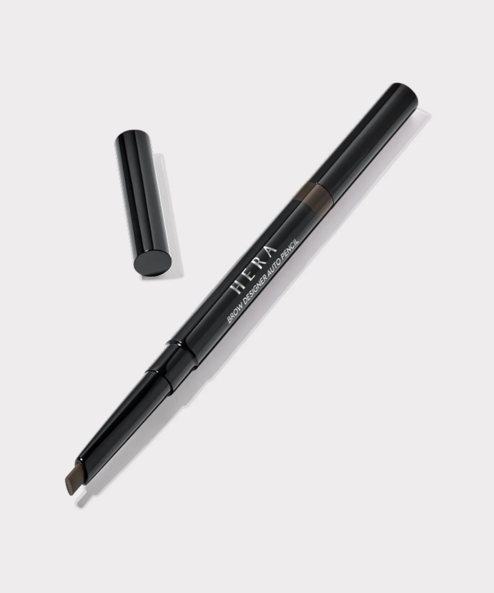 Décris l'image en français : HERA Brow Desighner Auto Pencil, stylo sourcils noir sur fond clair, marque HERA.
