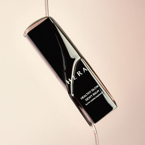 Décris l'image en français mentionnant le produit, la marque et le contexte visuel avec HERA  Healthy Glow Dewy Balm 10g