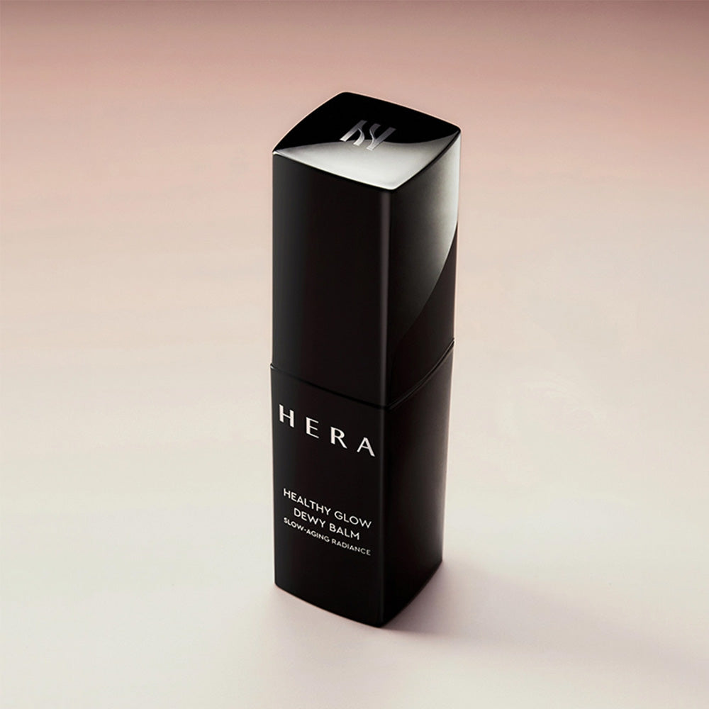 HERA  Healthy Glow Dewy Balm 10g de HERA, baume dédermés sur fond beige, packaging noir et logo, vue produit