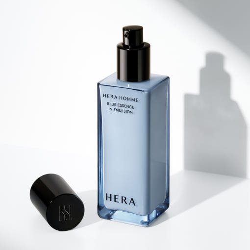 HERA  Homme Blue Essence in Emulsion 110m, flacon bleu HERA, sur fond clair moderne, photo produit en studio.