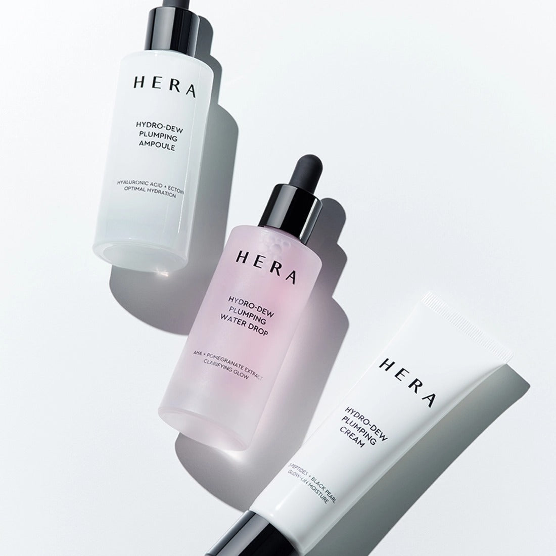 HERA Hydro-Dew Pluming Water Drop 50ml de HERA : flacons et crème sur fond blanc, gouttes hydratantes.