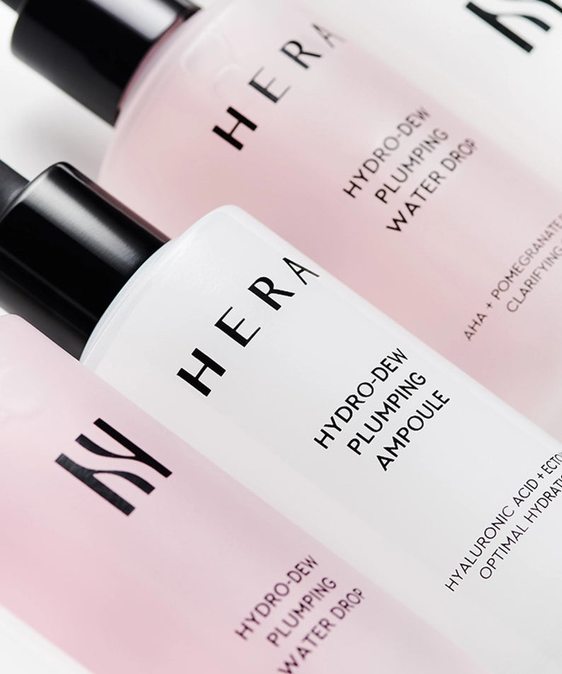 HERA Hydro-Dew Plumping Ampoule 50ml HERA, flacons rose pâle sur fond blanc, vue rapprochée en contexte beauté