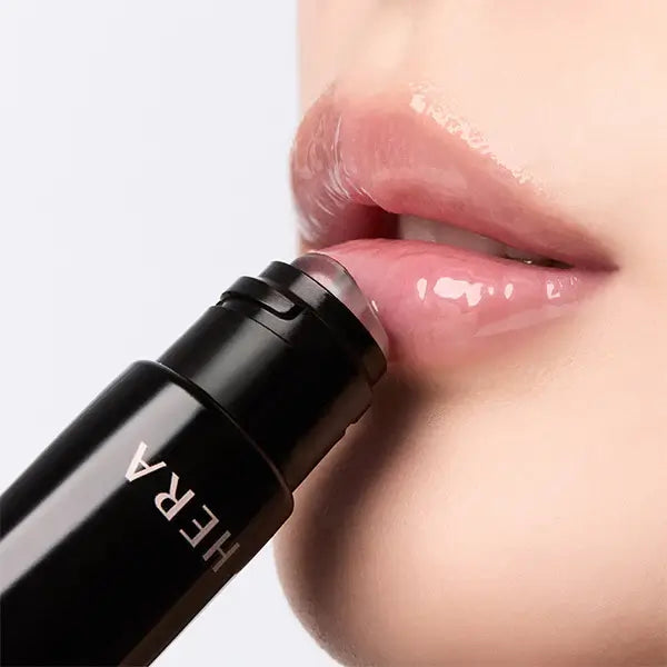 HERA  Lip Serum Intense 11g, application sur lèvres hydratées, flacon noir HERA, gros plan sur visage, lumière douce.