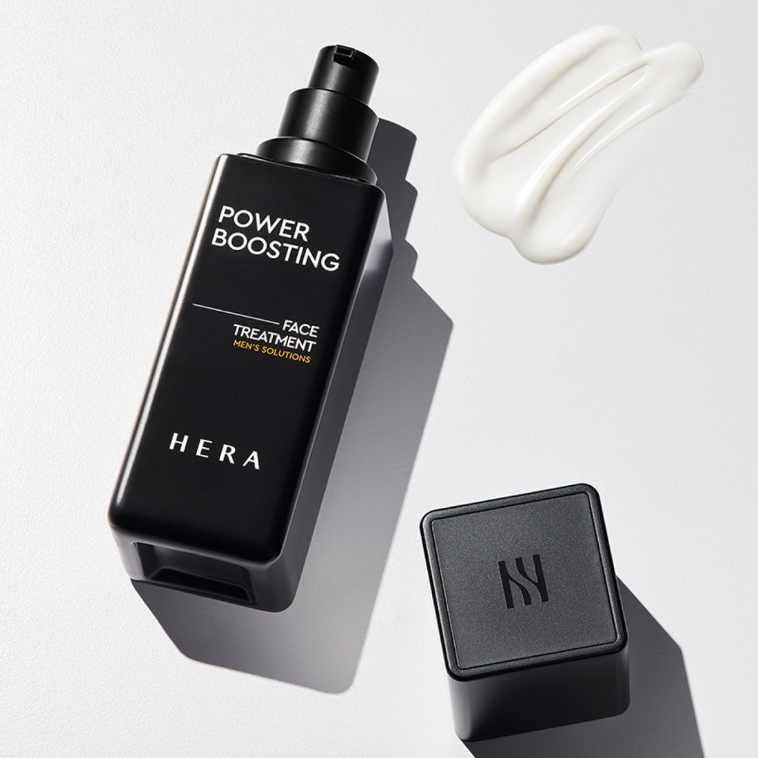HERA Powder Boosting Face Treatment 110ml HERA, flacon noir et texture crème blanche sur fond clair, contexte beauté