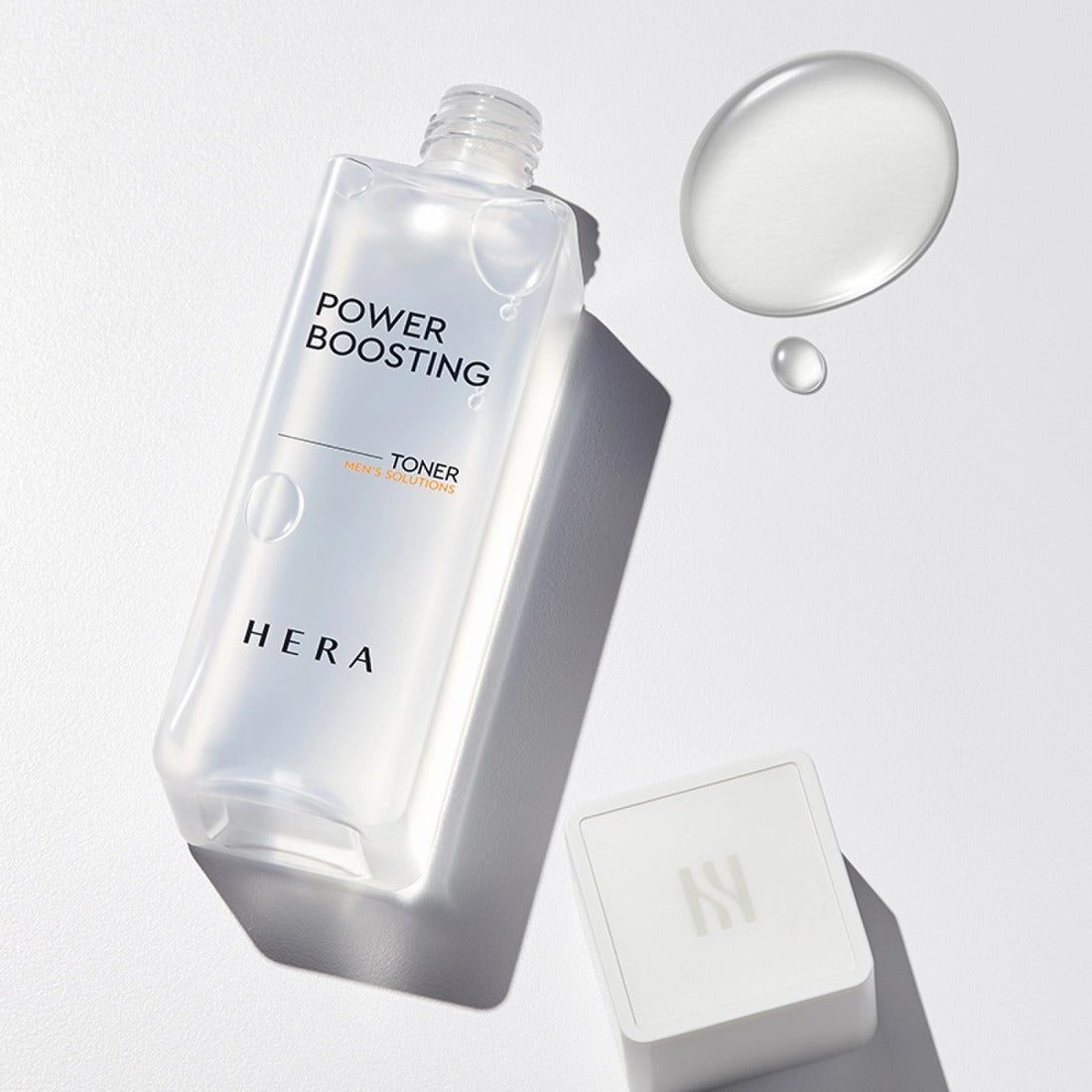 HERA Power Boosting Toner 150ml : flacon HERA sur fond clair, bulles et ombres pour une présentation skincare.