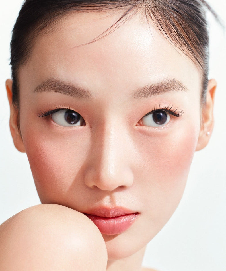 HERA Reflection Liquid Blush 7.5g : blush liquide sur peau, visage féminin maquillé, fond clair, produit beauté HERA