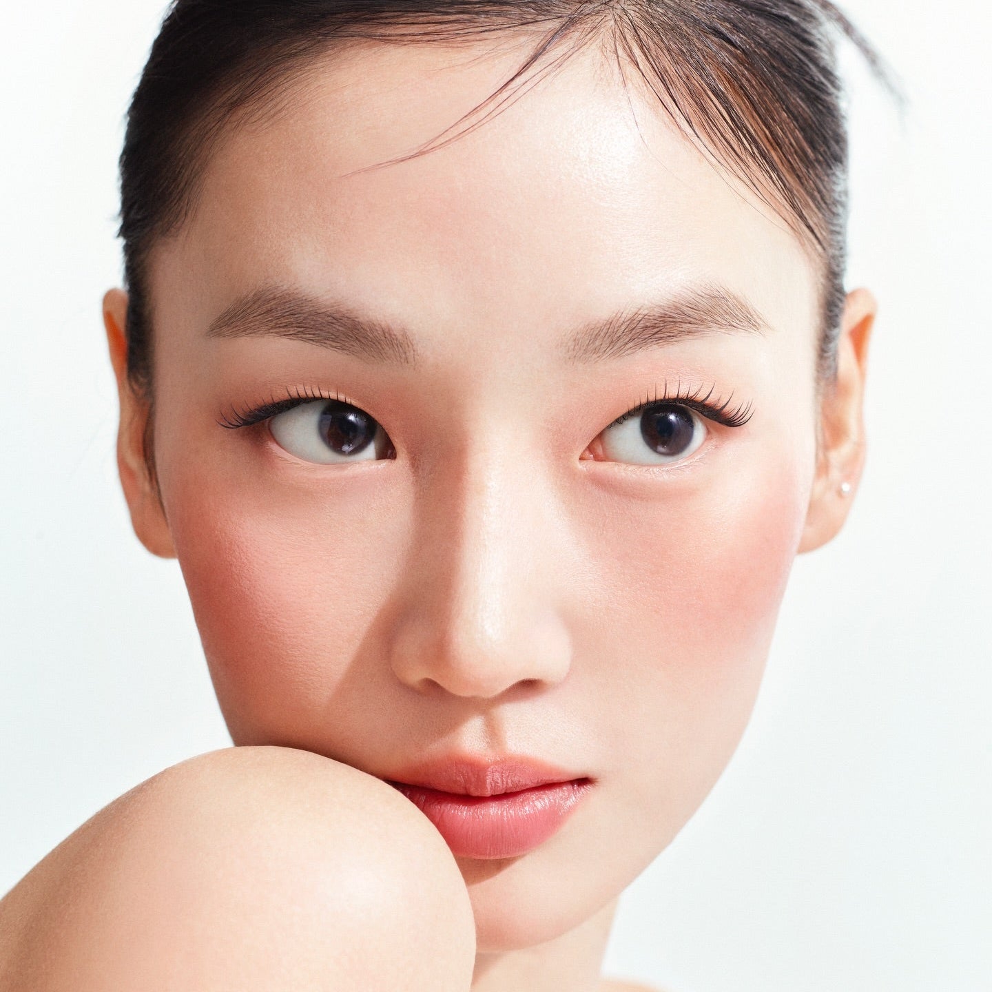 HERA Reflection Liquid Blush 7.5g : blush liquide sur peau, visage féminin maquillé, fond clair, produit beauté HERA