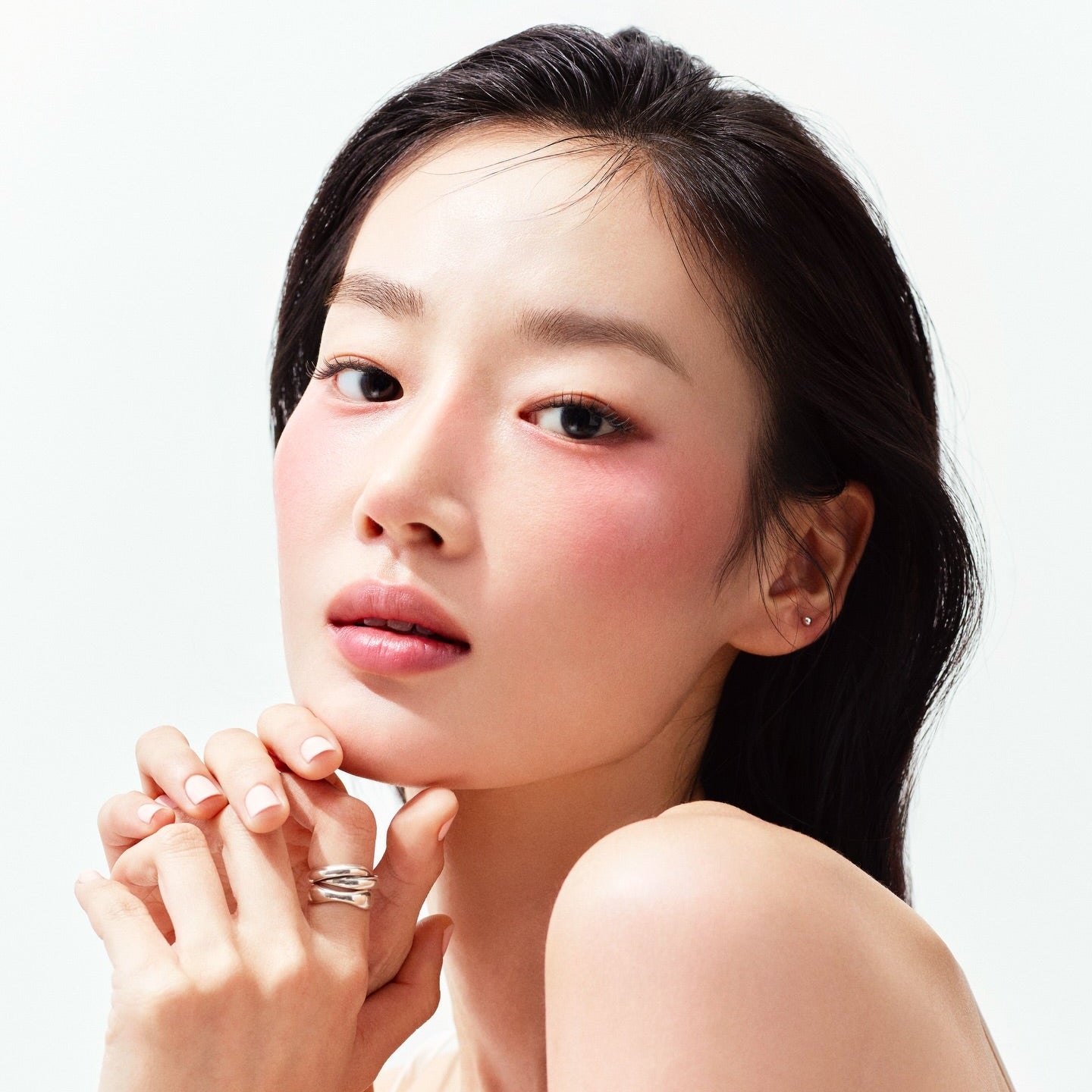 HERA Reflection Liquid Blush 7.5g : gros plan sur le visage maquillé avec touche de blush, style beauté sur fond clair.