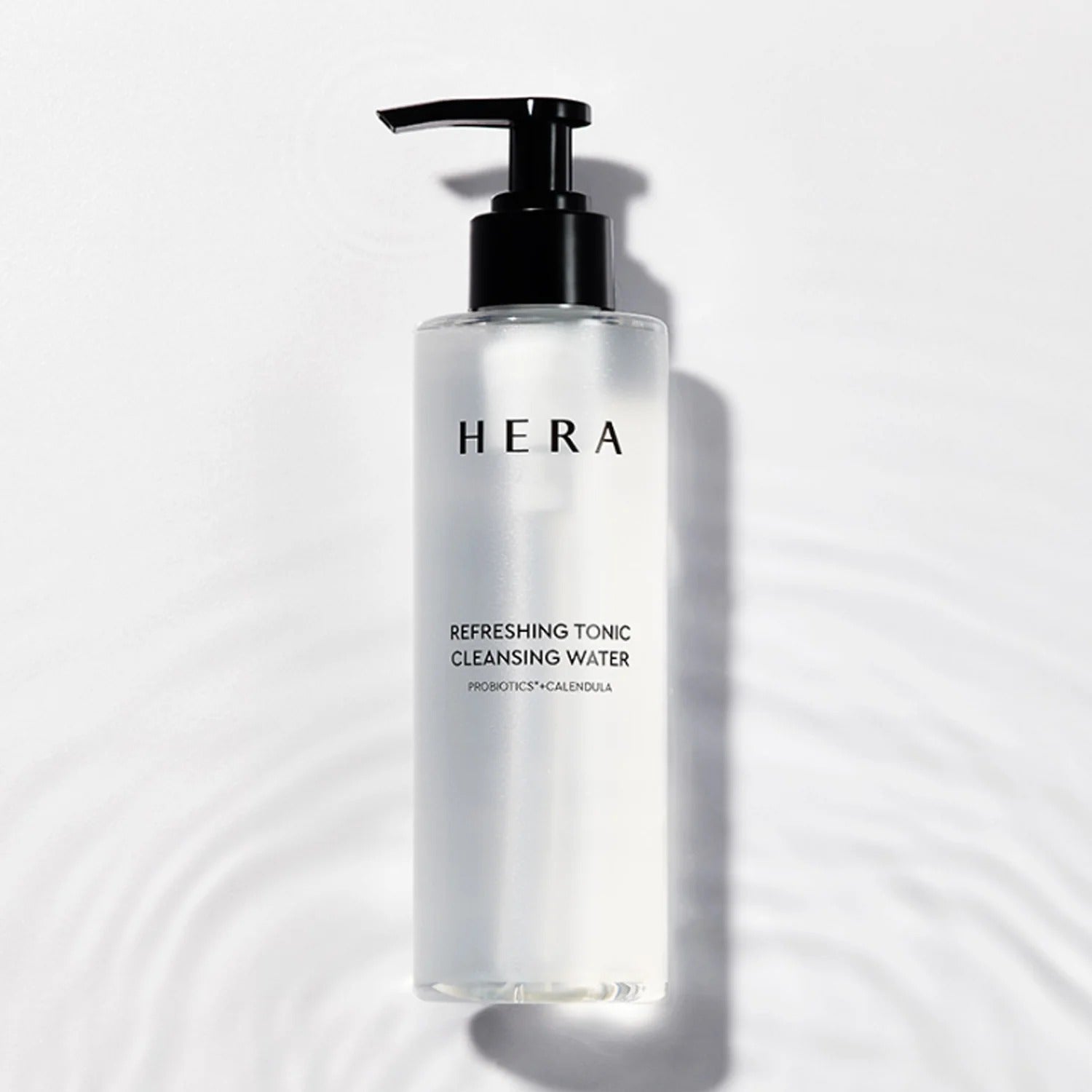 HERA Refreshing Tonic Cleansing Water 200ml, bouteille pompe HERA sur fond blanc avec ombres, en contexte cosmétique.