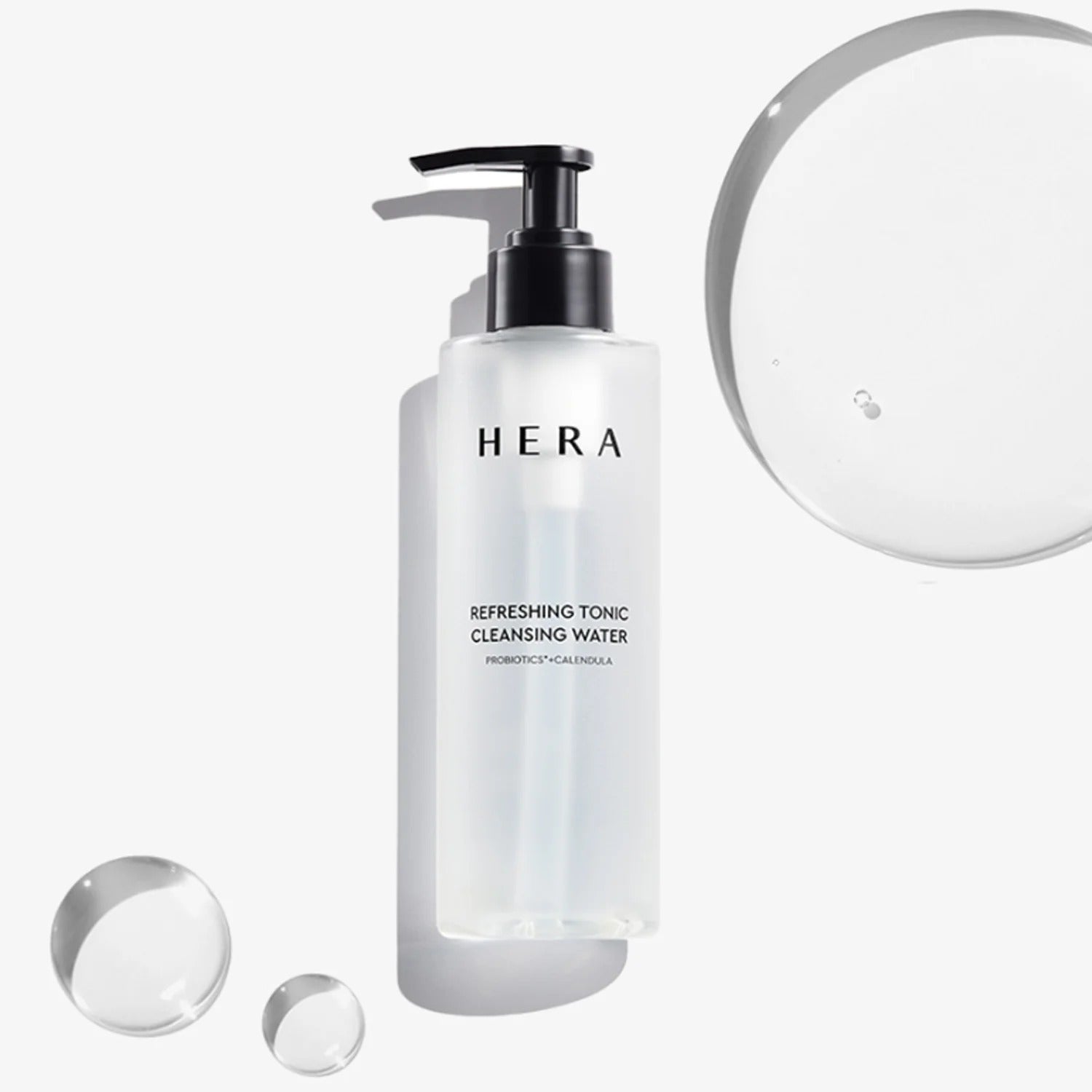 HERA Refreshing Tonic Cleansing Water 200ml, bouteille blanche avec pompe, gouttes et flacons sur fond clair.