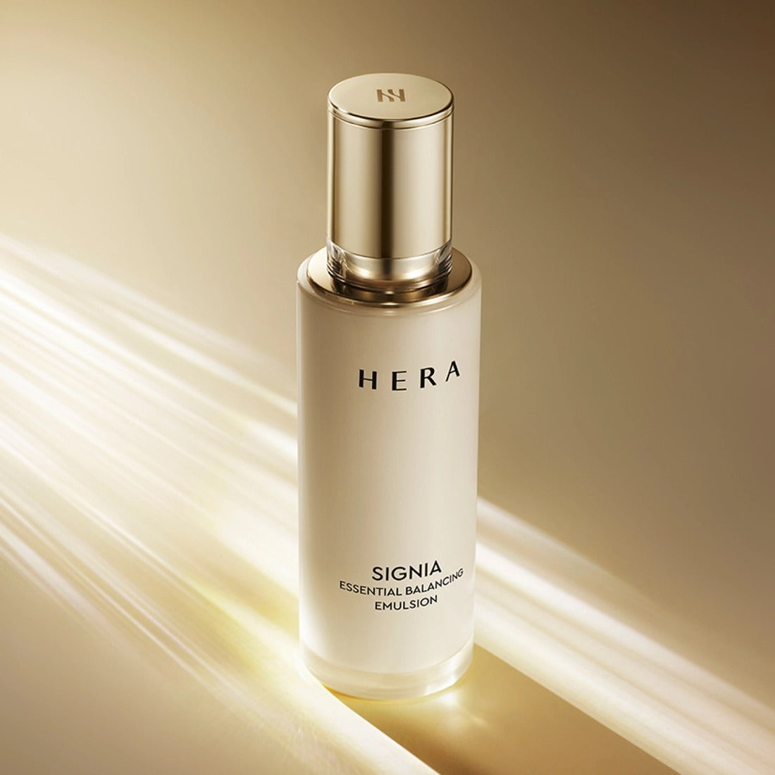 HERA Signa Essentail Balancing Emulsion 150ml de HERA, flacon doré sur fond beige avec lumière et lignes.