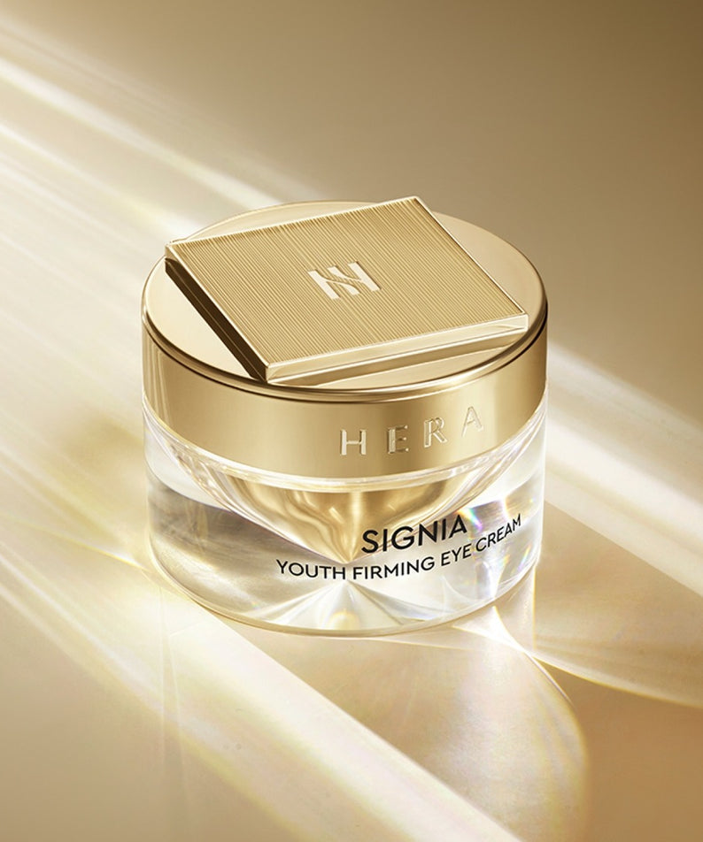 HERA Signa Youth Firming Eye Cream 30ml de HERA, pot crème doré sur fond beige lumineux, photo produit.