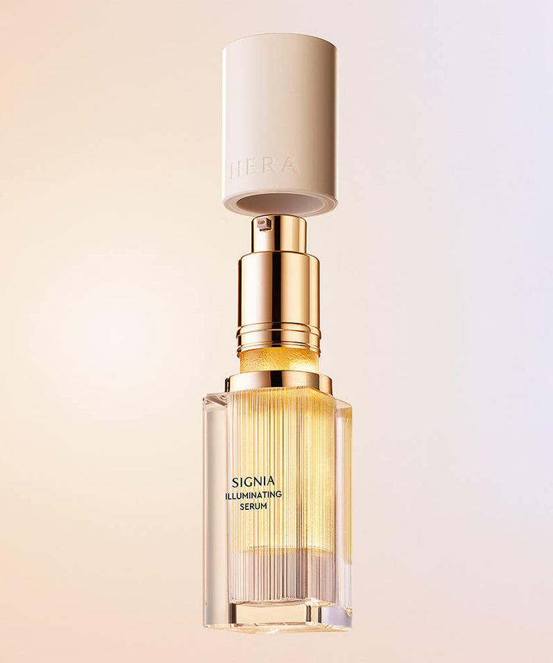 Décris l'image en français: HERA  Signia Illuminating Serum 30ml de la marque HERA, flacon doré sur fond clair.
