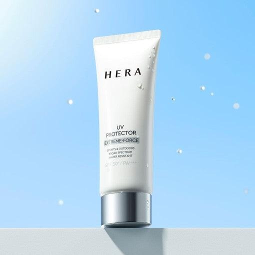 HERA UV Protector Extreme-Force Leports SPF50+PA++++, tube crème sur fond bleu, protection solaire en extérieur, gouttes d’eau.