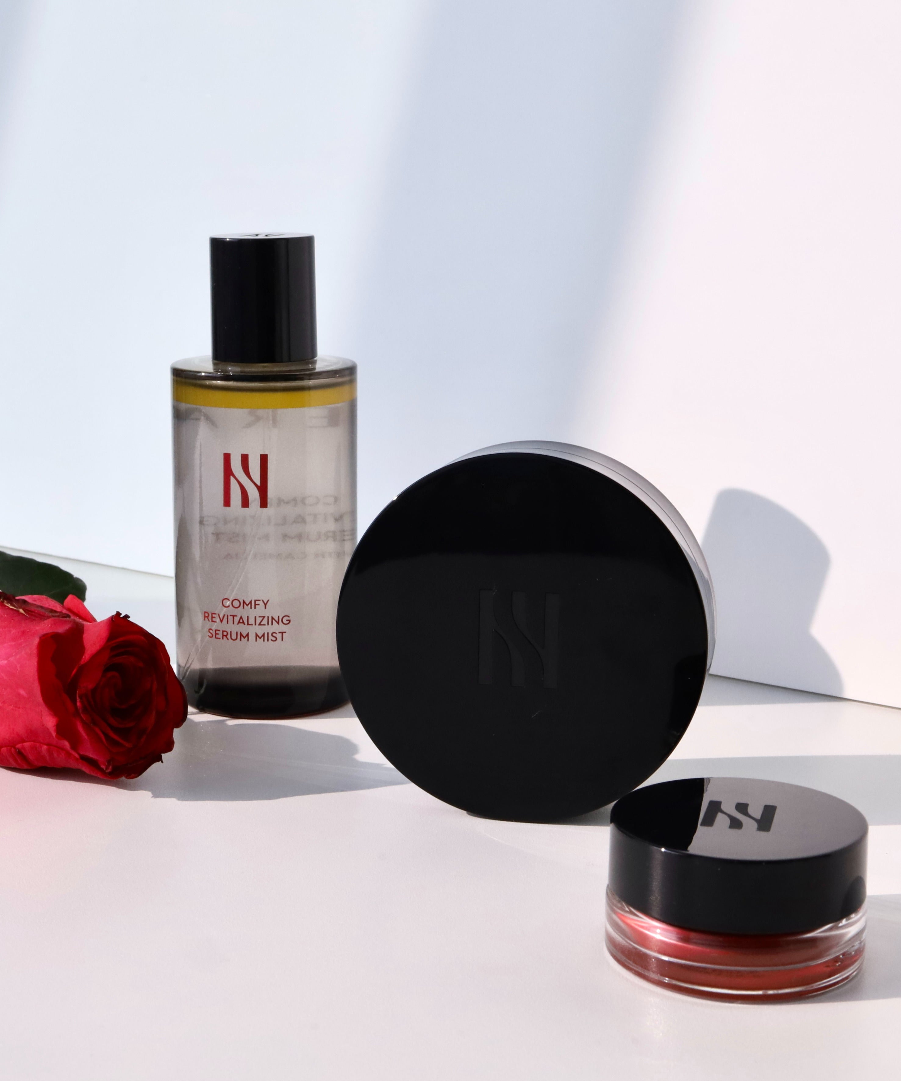 HERA Comfy Revitalizing Serum Mist 90ml avec rose rouge sur fond blanc élégant