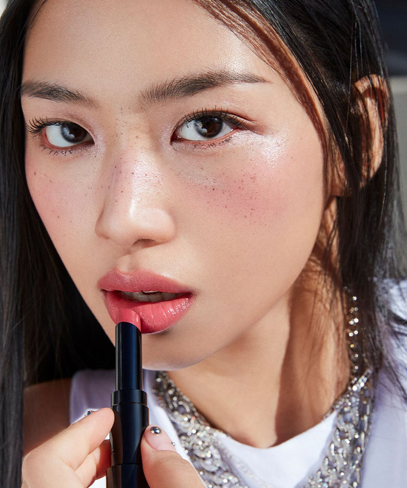 HERA Sensual Tinted Shine Stick 3.5g rouge à lèvres pour un éclat séduisant et naturel, femme utilisant le produit sur ses lèvres.