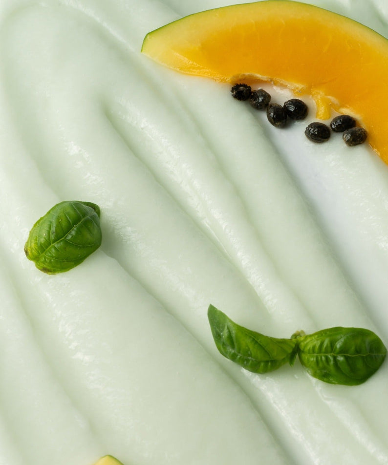 HERBLOOM  Green Papain Soft Peeling Gel 120g, gros plan sur gel translucide avec papaye et feuilles, fond crème verte.